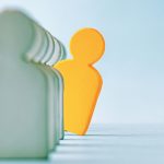 Selective focused image of a wooden profile of a person leaning out of line
