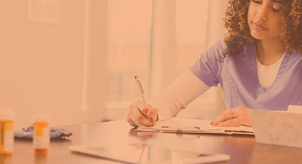 Clinician charting medical info at a kitchen table