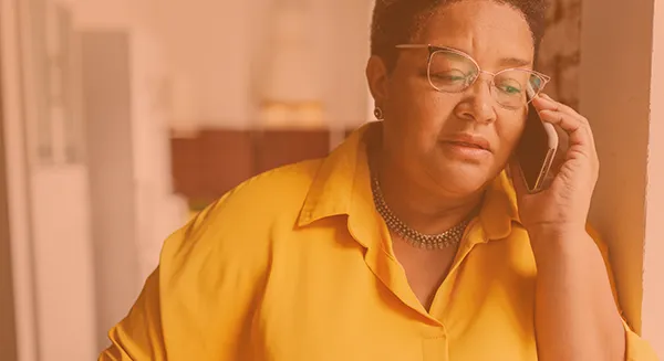 Caregiver on phone with a concerned look on her face