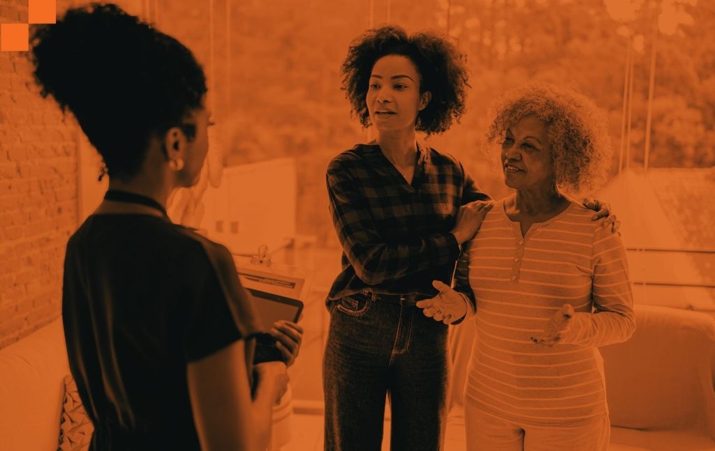 Daughter with elderly mother talking to a nurse