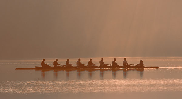 A crew team in a rowboat on river